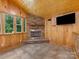 Cozy living room features a stone fireplace, wood-paneled walls, and natural light at 5322 Bridgeview Dr, Iron Station, NC 28080