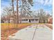 Street view of single story home with a long driveway and mature trees at 5442 Kinsale Ln, Charlotte, NC 28215