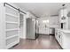 Modern kitchen featuring stainless steel appliances, white cabinets, hardwood floors, and a barn door at 5442 Kinsale Ln, Charlotte, NC 28215