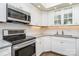 Bright kitchen featuring stainless steel appliances, white cabinets, and subway tile backsplash at 5742 Murrayhill Rd, Charlotte, NC 28210