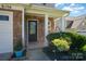 Inviting front porch with stone accents, manicured bushes, and decorative hanging flower basket at 6156 Kilchurn Dr, Fort Mill, SC 29707