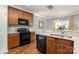 Modern kitchen equipped with stainless steel appliances, granite counters, and dark wood cabinets at 6156 Kilchurn Dr, Fort Mill, SC 29707