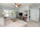 Upstairs living room with a comfortable sofa, large window, and ceiling fan for added comfort at 6156 Kilchurn Dr, Fort Mill, SC 29707