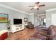 Relaxing living room with a cozy recliner, large TV, and hardwood flooring throughout the space at 6156 Kilchurn Dr, Fort Mill, SC 29707