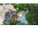 Aerial view of a backyard oasis featuring a pool, patio with outdoor seating, and lush landscaping at 617 Beauhaven Ln, Waxhaw, NC 28173