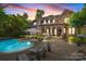 Expansive backyard featuring a pool, patio, lounge area, and well-maintained landscaping at sunset at 617 Beauhaven Ln, Waxhaw, NC 28173