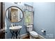 Powder room with sink, toilet, mirror and window at 617 Beauhaven Ln, Waxhaw, NC 28173