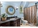 Well-lit bathroom features blue walls, dark cabinets, and a shower-tub combo at 617 Beauhaven Ln, Waxhaw, NC 28173