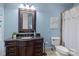 Well-lit bathroom with blue walls featuring dark cabinets, tile flooring, and shower-tub combo at 617 Beauhaven Ln, Waxhaw, NC 28173