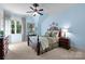 This bedroom features blue walls, a dark wood bed frame, and a ceiling fan at 617 Beauhaven Ln, Waxhaw, NC 28173