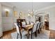 Bright dining room with wainscoting, hardwood floors, chandelier, and an arched entryway to other living spaces at 617 Beauhaven Ln, Waxhaw, NC 28173