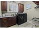 Functional laundry room featuring dark cabinetry, granite counters, and modern washer and dryer at 617 Beauhaven Ln, Waxhaw, NC 28173