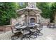Outdoor dining area with a stone fireplace, dining table and chairs for entertaining at 617 Beauhaven Ln, Waxhaw, NC 28173