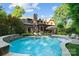 A beautiful backyard pool with a waterfall feature and ample lounge seating surrounded by greenery at 617 Beauhaven Ln, Waxhaw, NC 28173