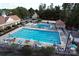 Aerial view of a community pool area with multiple pools, lounge chairs, and mature trees for shade at 7007 Creft Cir, Indian Trail, NC 28079