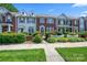 Charming townhome with brick and siding exterior, manicured landscaping, and a picket fence under a clear, blue sky at 7007 Creft Cir, Indian Trail, NC 28079