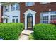 Brick townhome featuring a detailed front door, surrounded by lush greenery, and a well-maintained facade at 7007 Creft Cir, Indian Trail, NC 28079