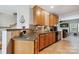 Kitchen featuring granite countertops, tile backsplash, and wood cabinets with an open view to the living room at 7007 Creft Cir, Indian Trail, NC 28079
