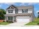 Two-story home with stone accents, a two-car garage, light gray siding, and a manicured lawn at 7311 Jerimoth Dr, Charlotte, NC 28215