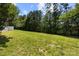 Expansive backyard featuring a lush lawn and mature trees, offering ample space for recreation and outdoor activities at 7315 Gasper Ln, Fort Mill, SC 29707