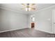 Neutral bedroom with ceiling fan, wood-look floors, and a doorway to bathroom at 7315 Gasper Ln, Fort Mill, SC 29707