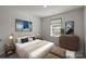 Staged main bedroom with a luxurious bed, modern art, and natural light at 853 Gerard Bay Dr, Fort Mill, SC 29715