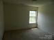 Bedroom featuring a window offering natural light, neutral walls, and carpeted floors at 10516 Pickerel Ln, Charlotte, NC 28213