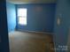 Bright bedroom featuring blue walls, a window for natural light, and carpeted floors at 10516 Pickerel Ln, Charlotte, NC 28213