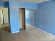 Comfortable bedroom with blue walls, mirrored closet doors, and carpeted floors at 10516 Pickerel Ln, Charlotte, NC 28213