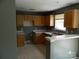 Functional kitchen with wooden cabinets, ample counter space, and a cozy breakfast bar at 10516 Pickerel Ln, Charlotte, NC 28213