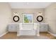 Bathroom with a bathtub, two vanities with mirrors, white cabinets, and brown tiled floors at 112 Doyle Farm Ln, Mooresville, NC 28115
