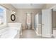 Bright bathroom featuring a walk-in shower, soaking tub, vanity, and neutral walls at 112 Doyle Farm Ln, Mooresville, NC 28115
