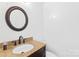 Bright bathroom with a granite vanity top, dark cabinets, oval sink, and round mirror at 112 Doyle Farm Ln, Mooresville, NC 28115