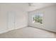 Bright bedroom with a window, neutral carpet, white walls, and a ceiling fan at 112 Doyle Farm Ln, Mooresville, NC 28115