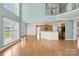 Open-concept living room features hardwood floors, large windows, and view of kitchen and second story landing at 112 Doyle Farm Ln, Mooresville, NC 28115