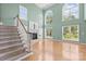 Living room with staircase, hardwood floors, fireplace, and large windows providing ample natural light at 112 Doyle Farm Ln, Mooresville, NC 28115