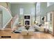 Bright living room with fireplace, staircase, hardwood floors, and large windows providing ample natural light at 112 Doyle Farm Ln, Mooresville, NC 28115