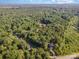 Aerial view of a wooded property, featuring mature trees and a home with a long driveway at 11201 Johnson Davis Rd, Huntersville, NC 28078