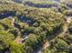 Aerial view of a wooded property, featuring mature trees and nearby homes and roads at 11201 Johnson Davis Rd, Huntersville, NC 28078