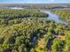 Picturesque aerial view of a lakefront property surrounded by mature trees and lush greenery at 11201 Johnson Davis Rd, Huntersville, NC 28078
