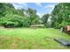 Large backyard featuring a lush lawn, mature trees, and a house in the background at 11201 Johnson Davis Rd, Huntersville, NC 28078
