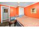 A bright orange bedroom with a single bed, small table, and chair at 11201 Johnson Davis Rd, Huntersville, NC 28078