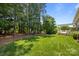 Spacious backyard featuring mature trees, a lush green lawn, and a pergola-covered deck at 11329 Fullerton Place Nw Dr, Huntersville, NC 28078