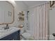 Stylish bathroom featuring a modern sink, patterned shower curtain, and decorative shelves at 11329 Fullerton Place Nw Dr, Huntersville, NC 28078
