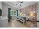 Serene bedroom with a queen-sized bed, wallpapered accent wall, and neutral color scheme for relaxation at 11329 Fullerton Place Nw Dr, Huntersville, NC 28078