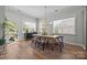 Bright dining room features a stylish light fixture, modern furniture, and large windows overlooking the backyard at 11329 Fullerton Place Nw Dr, Huntersville, NC 28078