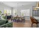 Bright dining room with large windows, modern chandelier, and open access to the kitchen at 11329 Fullerton Place Nw Dr, Huntersville, NC 28078