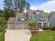 Aerial view of a charming two-story home with blue siding, landscaped yard, and a three-car garage at 11329 Fullerton Place Nw Dr, Huntersville, NC 28078
