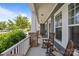 Inviting covered front porch with brick pillars, rocking chairs, and a view of the surrounding neighborhood at 11329 Fullerton Place Nw Dr, Huntersville, NC 28078