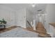 Bright hallway with wood floors, white trim and doors, area rug, and stairs to another floor at 11329 Fullerton Place Nw Dr, Huntersville, NC 28078